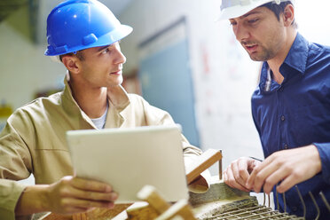 Construction worker and foreman discussing roof beams - ZEF001851