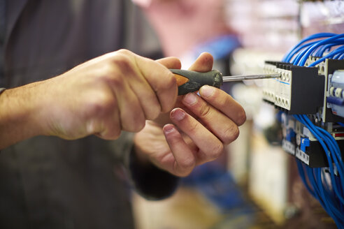 Nahaufnahme eines Elektrikers bei der Arbeit mit einem Schraubenzieher - ZEF001863