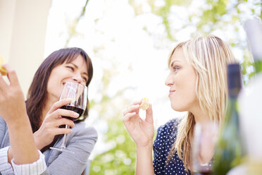 Zwei glückliche Frauen mit Rotwein und Weißbrot - ZEF001476