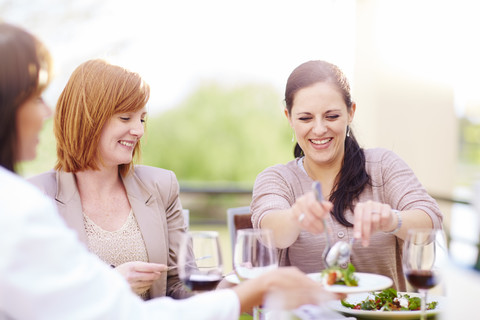 Freunde bei Salat und Rotwein auf der Loggia, lizenzfreies Stockfoto