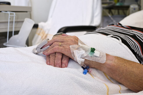 Hands of senior man with cannulae and band-aid being in intensive care - LAF001083