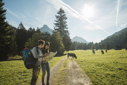 Austria, Tyrol, Tannheimer Tal, two young hikers with hiking map - UUF002110