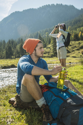 Österreich, Tirol, Tannheimer Tal, zwei junge Wanderer beim Ausruhen, lizenzfreies Stockfoto