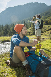 Austria, Tyrol, Tannheimer Tal, two young hikers relaxing - UUF002122