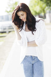 Portrait of smiling young woman with hand in her hair - GDF000478