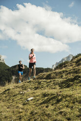 Austria, Tyrol, Tannheim Valley, young couple jogging in mountains - UUF002064