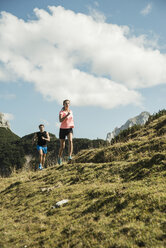 Österreich, Tirol, Tannheimer Tal, junges Paar joggt in den Bergen - UUF002064