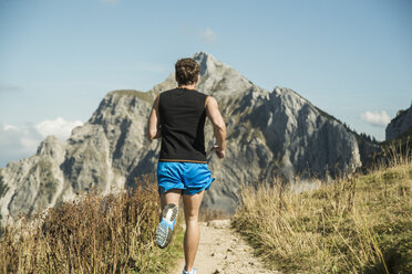 Austria, Tyrol, Tannheim Valley, young man jogging in mountains - UUF002070