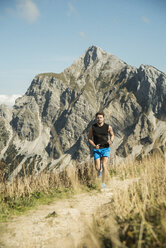 Austria, Tyrol, Tannheim Valley, young man jogging in mountains - UUF002073