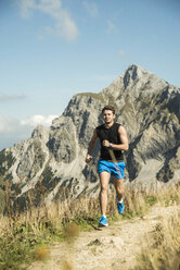 Austria, Tyrol, Tannheim Valley, young man jogging in mountains - UUF002074