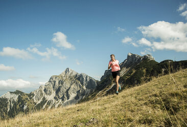 Austria, Tyrol, Tannheim Valley, young woman jogging in mountains - UUF002075