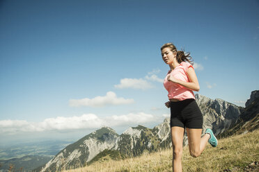 Österreich, Tirol, Tannheimer Tal, junge Frau joggt in den Bergen - UUF002076