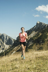 Österreich, Tirol, Tannheimer Tal, junge Frau joggt in den Bergen - UUF002077