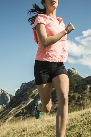 Österreich, Tirol, Tannheimer Tal, junge Frau joggt in den Bergen, lizenzfreies Stockfoto