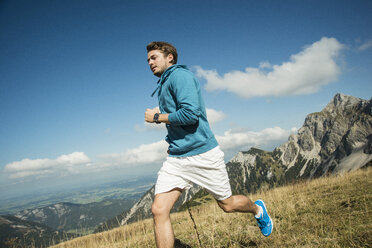 Österreich, Tirol, Tannheimer Tal, junger Mann beim Joggen in den Bergen - UUF002087