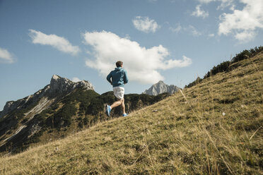 Austria, Tyrol, Tannheim Valley, young man jogging in mountains - UUF002091