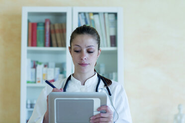 Portrait of young female doctor using digital tablet - SGF000864