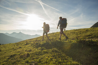 Austria, Tyrol, Tannheimer Tal, young couple hiking on alpine meadow - UUF002227