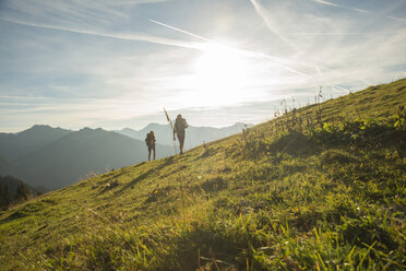 Austria, Tyrol, Tannheimer Tal, young couple hiking on alpine meadow - UUF002230