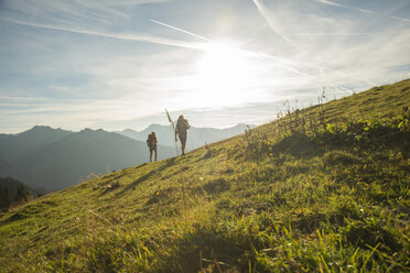 Österreich, Tirol, Tannheimer Tal, junges Paar wandert auf Almwiese - UUF002230