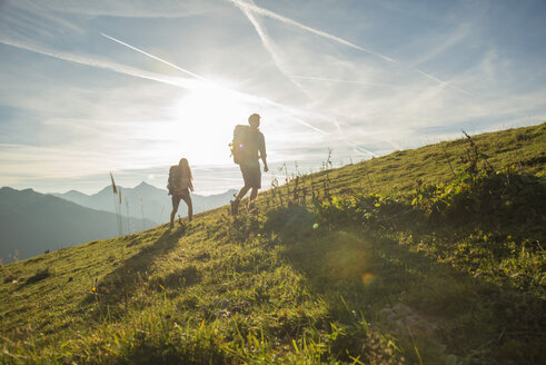 Österreich, Tirol, Tannheimer Tal, junges Paar wandert auf Almwiese - UUF002231