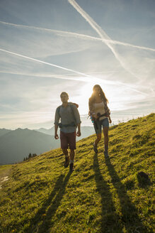 Österreich, Tirol, Tannheimer Tal, junges Paar wandert auf Almwiese - UUF002326