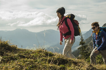 Austria, Tyrol, Tannheimer Tal, young couple hiking on alpine meadow - UUF002255