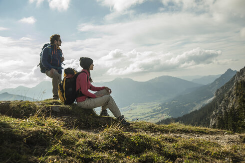 Österreich, Tirol, Tannheimer Tal, junges Paar rastet auf Wandertour - UUF002260