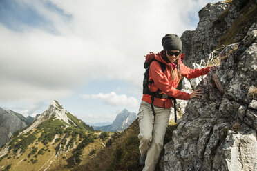 Österreich, Tirol, Tannheimer Tal, junge Frau wandert auf Felsen - UUF002271