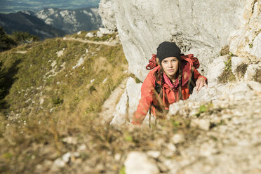 Österreich, Tirol, Tannheimer Tal, junge Frau wandert auf Felsen - UUF002274