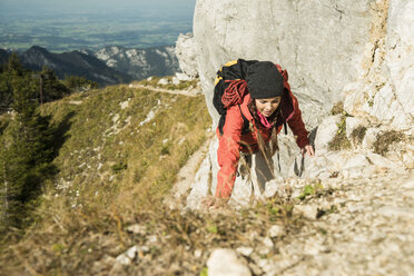 Österreich, Tirol, Tannheimer Tal, junge Frau wandert auf Felsen - UUF002275