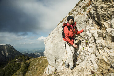 Österreich, Tirol, Tannheimer Tal, junge Frau wandert auf Felsen - UUF002276