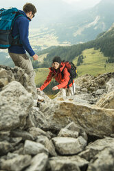 Österreich, Tirol, Tannheimer Tal, junges Paar beim Wandern auf Felsen - UUF002288