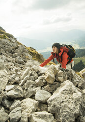 Austria, Tyrol, Tannheimer Tal, young woman climbing on rocks - UUF002293