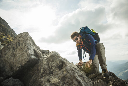 Österreich, Tirol, Tannheimer Tal, junger Mann beim Klettern am Fels - UUF002224