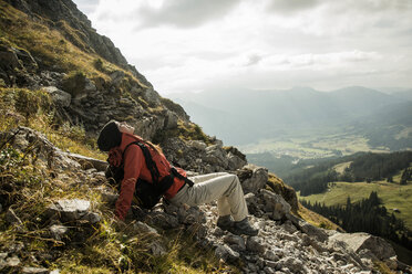 Österreich, Tirol, Tannheimer Tal, junge Wanderin beim Ausruhen in den Bergen - UUF002221