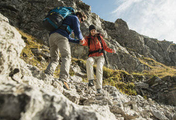 Austria, Tyrol, Tannheimer Tal, young couple hiking on rocks - UUF002218