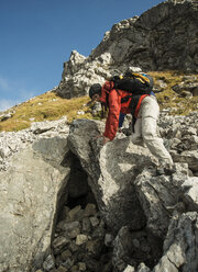 Österreich, Tirol, Tannheimer Tal, junge Frau klettert auf Felsen - UUF002216