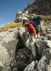 Österreich, Tirol, Tannheimer Tal, junges Paar beim Wandern auf Felsen - UUF002215