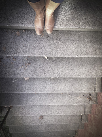 Frau in Stiefeln auf der Treppe, lizenzfreies Stockfoto