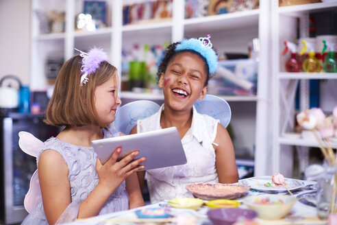 Zwei Mädchen benutzen ein digitales Tablet auf einer Geburtstagsparty - ZEF001373