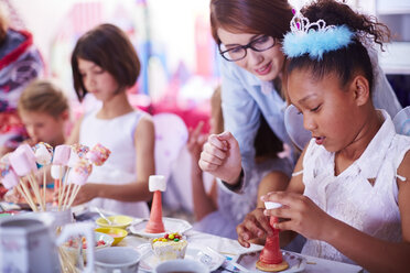 Mädchen garnieren Süßigkeiten auf einer Geburtstagsparty - ZEF001378