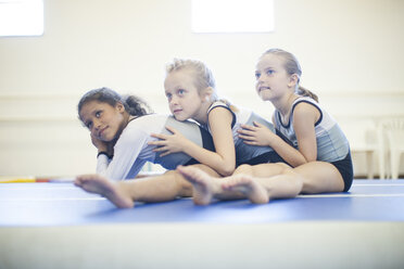 Drei Mädchen machen Gymnastikübungen am Boden - ZEF001313