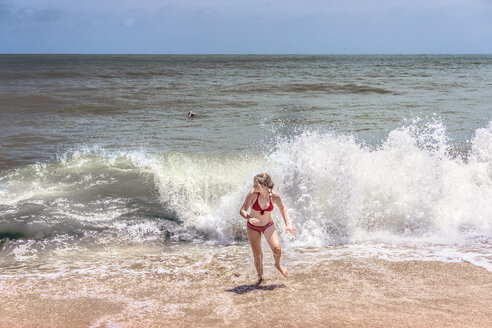 Thailand, Khao Lak, Mädchen läuft aus dem Wasser am Bang Niang Strand - WEF000258
