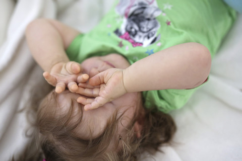 Baby Mädchen reibt sich die Augen, lizenzfreies Stockfoto