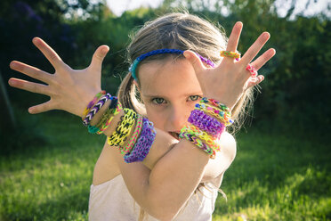 Portrait of little girl showing her loom bracelets - SARF000919