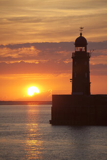 Germany, Bremen, Bremerhaven, Lighthouse on the pier at sunset - OLEF000041