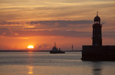 Germany, Bremen, Bremerhaven, Lighthouse on the pier at sunset - OLEF000040