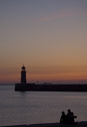 Germany, Bremen, Bremerhaven, Lighthouse on the pier at sunset - OLEF000039