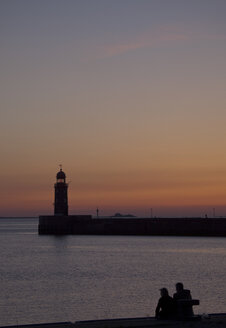 Germany, Bremen, Bremerhaven, Lighthouse on the pier at sunset - OLEF000039